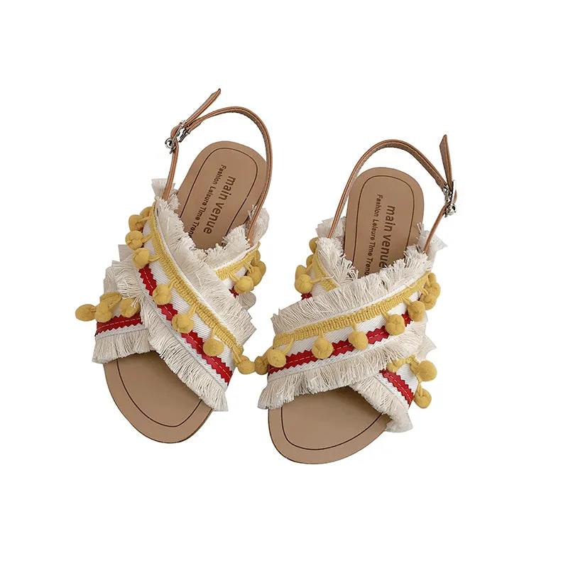 BOOPDO DESIGN CROSS OVER FLAT SANDALS WITH TASSEL AND POM POM DETAIL