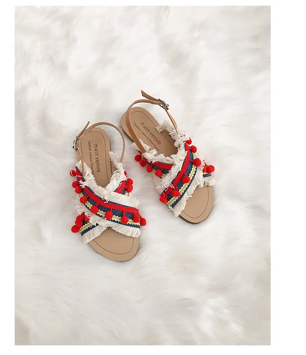 BOOPDO DESIGN CROSS OVER FLAT SANDALS WITH TASSEL AND POM POM DETAIL